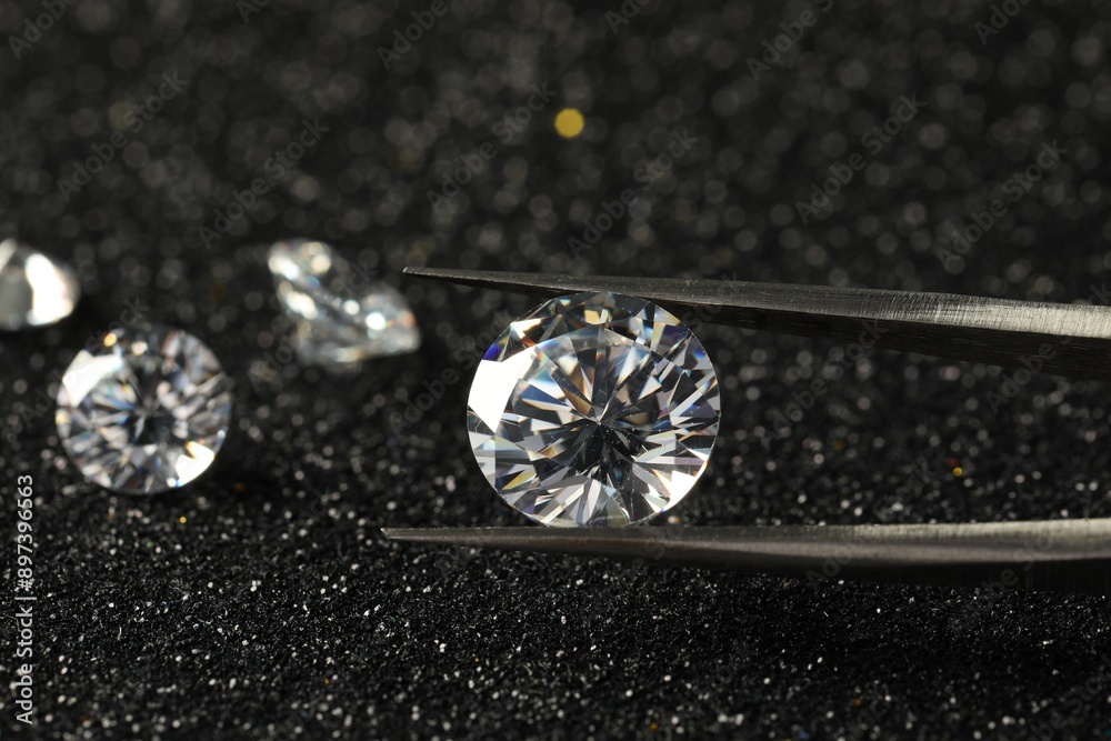 Tweezers with beautiful diamond on dark shiny background, closeup Tweezers with beautiful diamond on dark shiny background, closeup