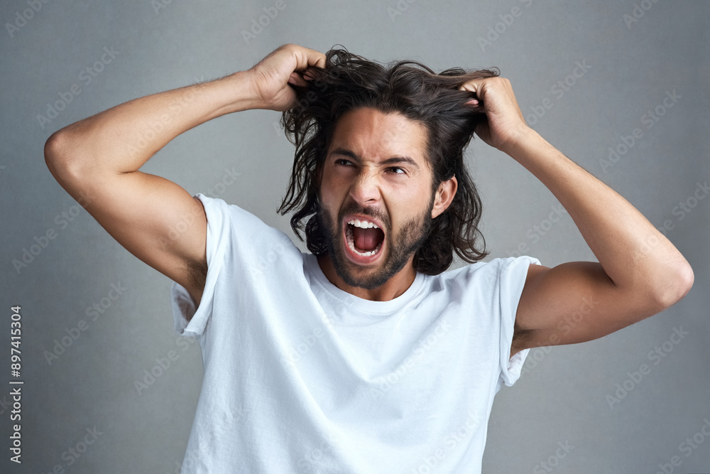 Studio, man and frustrated with pulling of hair for bad news, stress and anxiety on gray background. Angry, male person and expression with screaming for panic attack, mental health and ptsd trauma Studio, man and frustrated with pulling of hair for bad news, stress and anxiety on gray background. Angry, male person and expression with screaming for panic attack, mental health and ptsd trauma
