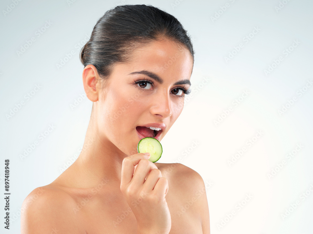 Beauty, portrait and woman eating in studio with cucumber for facial routine, sjkincare or glow with white background. Body, mockup and hand of model for clean, organic treatment or nutrition Beauty, portrait and woman eating in studio with cucumber for facial routine, sjkincare or glow with white background. Body, mockup and hand of model for clean, organic treatment or nutrition