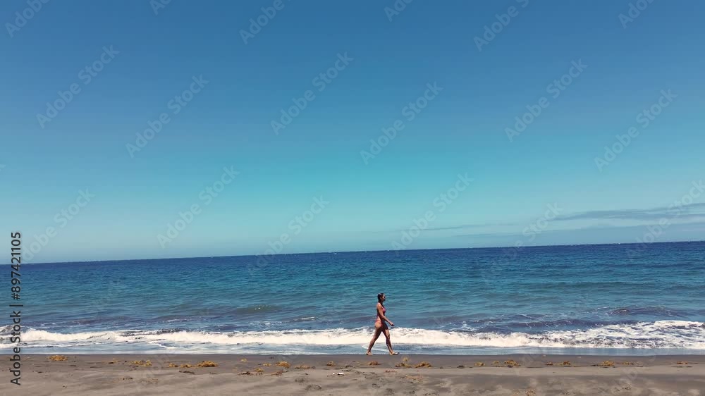 Idyllic scene of a woman relaxing unwinding at unspoiled virgin beach in Gran Canaria, Spain during summer time on vacations Idyllic scene of a woman relaxing unwinding at unspoiled virgin beach in Gran Canaria, Spain during summer time on vacations