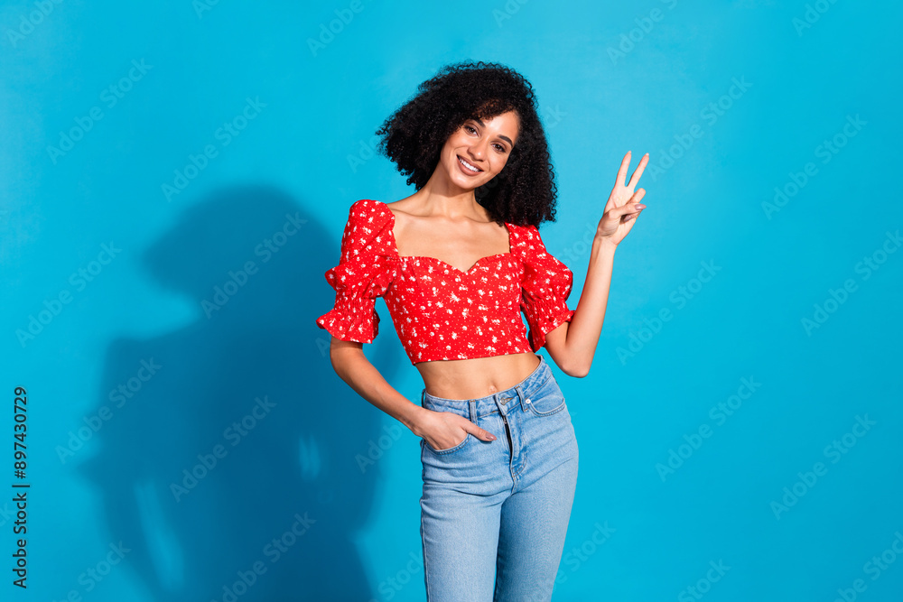 Portrait of gorgeous young woman show v-sign wear top isolated on blue color background Portrait of gorgeous young woman show v-sign wear top isolated on blue color background