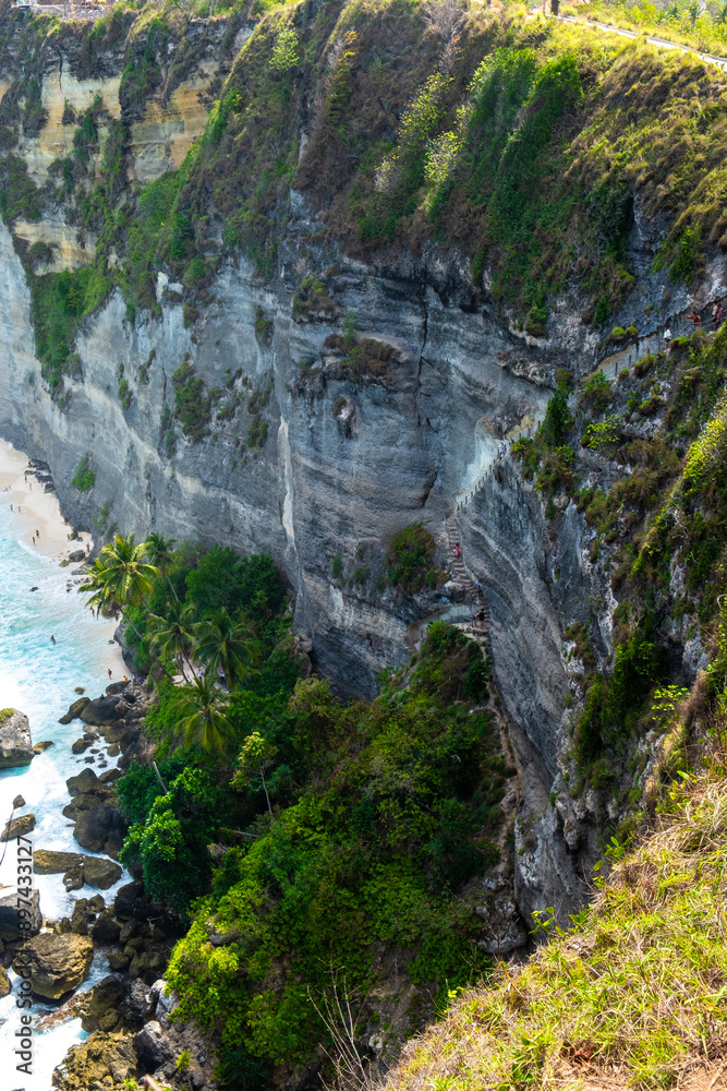 A cliffside path with a breathtaking view of the blue ocean and lush greenery, ideal for adventurers and nature lovers. A cliffside path with a breathtaking view of the blue ocean and lush greenery, ideal for adventurers and nature lovers.