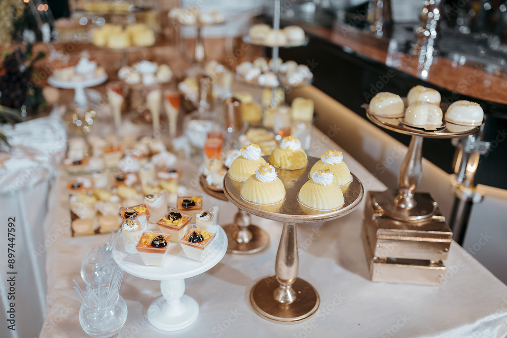 A table full of desserts including cakes, cupcakes, and pastries. The table is set up for a party or event A table full of desserts including cakes, cupcakes, and pastries. The table is set up for a party or event