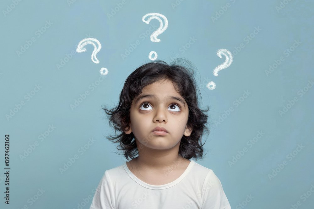 A little Indian model boy thinking with question marks floating above her head on a light blue background