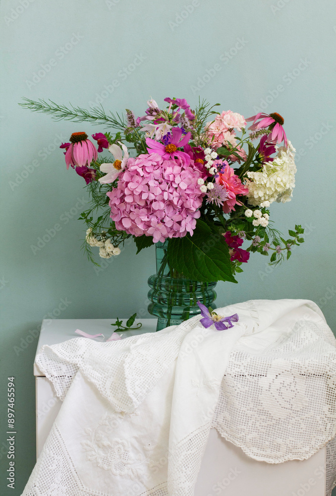 A bouquet of summer flowers in the room. Hydrangea, rose, echinacea, mint, snapdragon, asparagus and other flowers.
