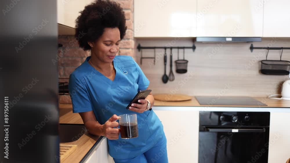 African American nurse enjoying coffee at home and using smartphone African American nurse enjoying coffee at home and using smartphone