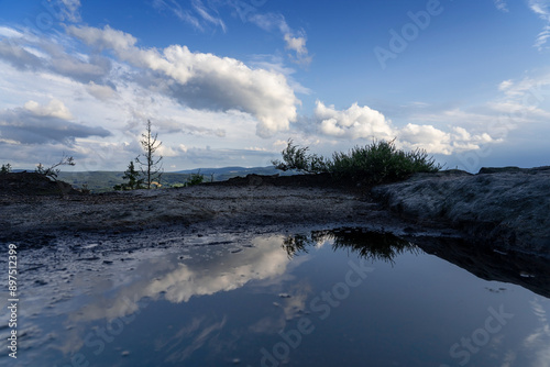 Reflecting clouds in a puddle along with the surrounding mountains. Stolowe Mountains, Klodzka Valley, Lower Silesia Voivodeship photo