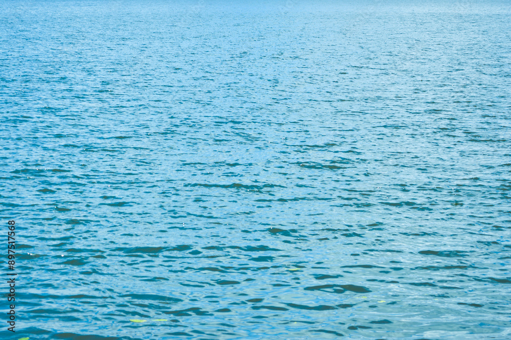 A mirror-like lake surface reflects the sky, undisturbed and peaceful A mirror-like lake surface reflects the sky, undisturbed and peaceful