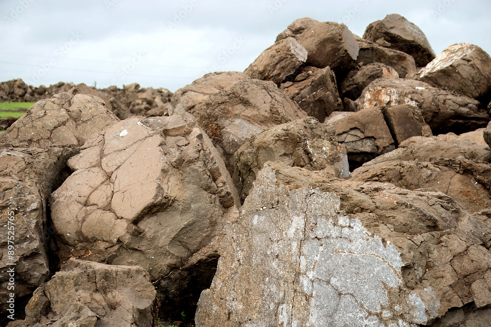 The rough boulders stacked against a brooding sky, This stock image showcases the raw beauty of nature, with a collection of weathered boulders contrasting against an overcast sky. The rough boulders stacked against a brooding sky, This stock image showcases the raw beauty of nature, with a collection of weathered boulders contrasting against an overcast sky.