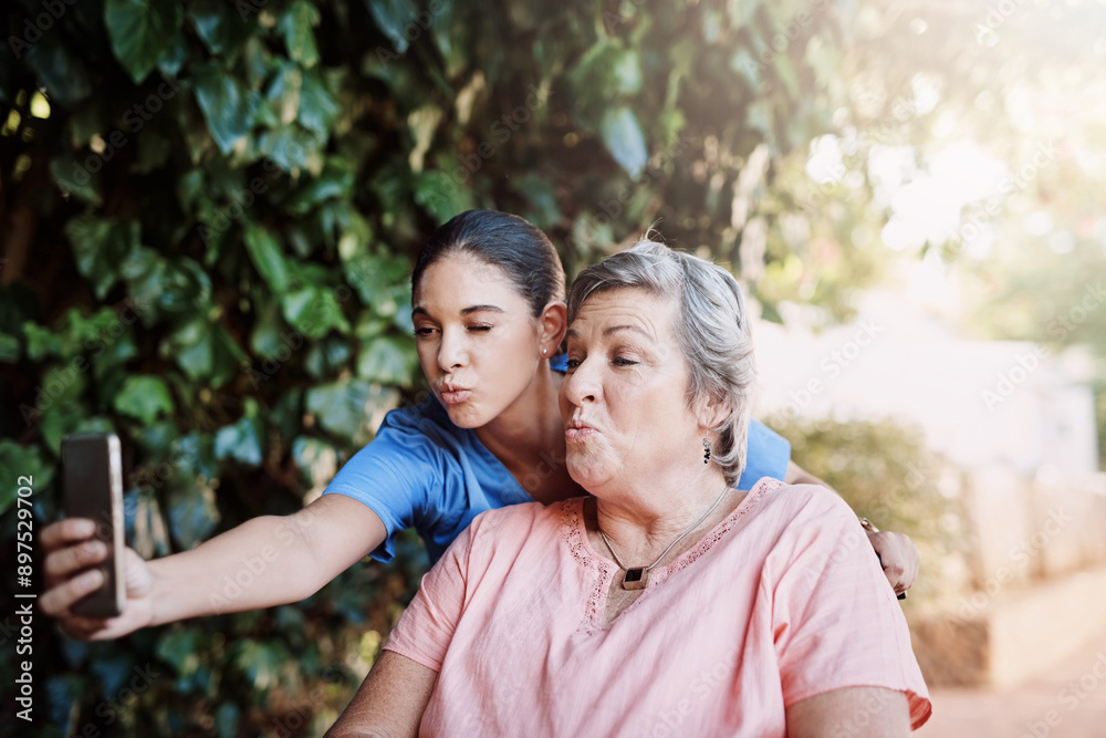 Healthcare, kiss and selfie of nurse with old woman outdoor at retirement home for social media. Assisted living, medical or memory with caregiver and senior patient pouting for photograph in garden Healthcare, kiss and selfie of nurse with old woman outdoor at retirement home for social media. Assisted living, medical or memory with caregiver and senior patient pouting for photograph in garden