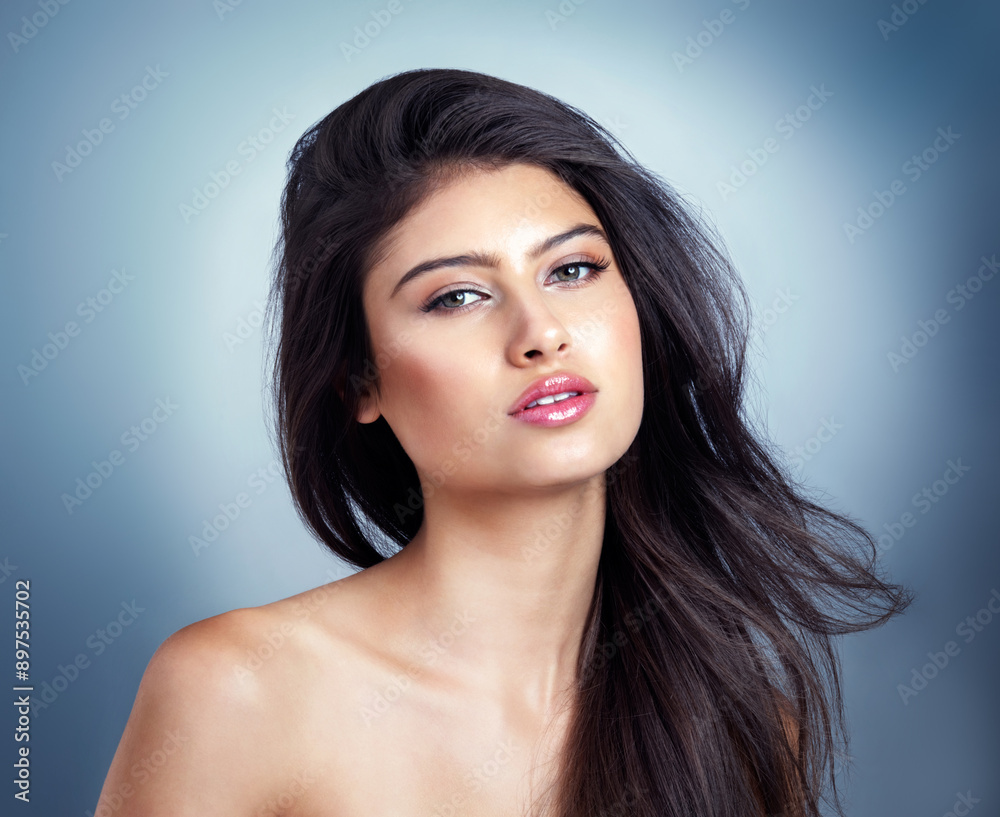 Naklejka premium Hair salon, confident and portrait of woman in studio for haircare, healthy texture and growth. Salon, beauty and person with cosmetics for keratin treatment, wellness and shampoo on blue background