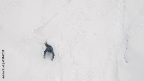 snowboarder rolling down mountainside falls into snowdrift, slow motion