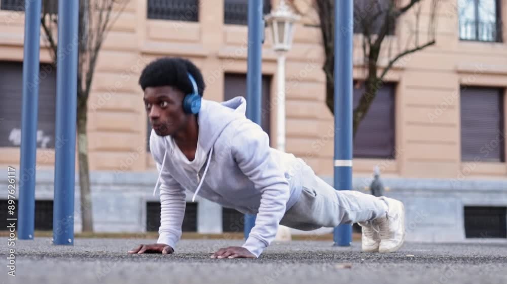 Handsome african american young male doing push-ups in calisthenics park.