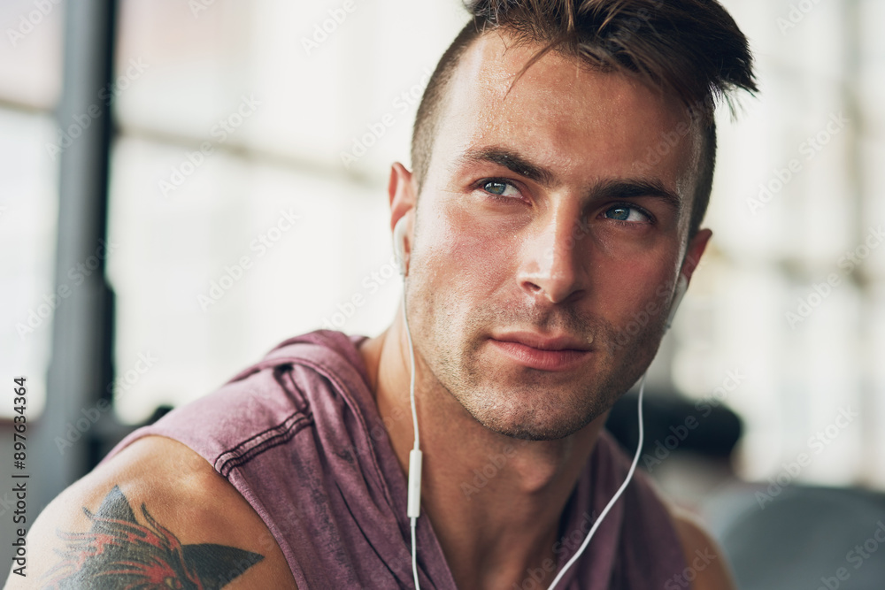 Man, thought and music in gym for fitness, exercise and wellness with radio for motivation. Training, thinking and male bodybuilder on break from cardio, workout or earphones for listening to podcast Man, thought and music in gym for fitness, exercise and wellness with radio for motivation. Training, thinking and male bodybuilder on break from cardio, workout or earphones for listening to podcast