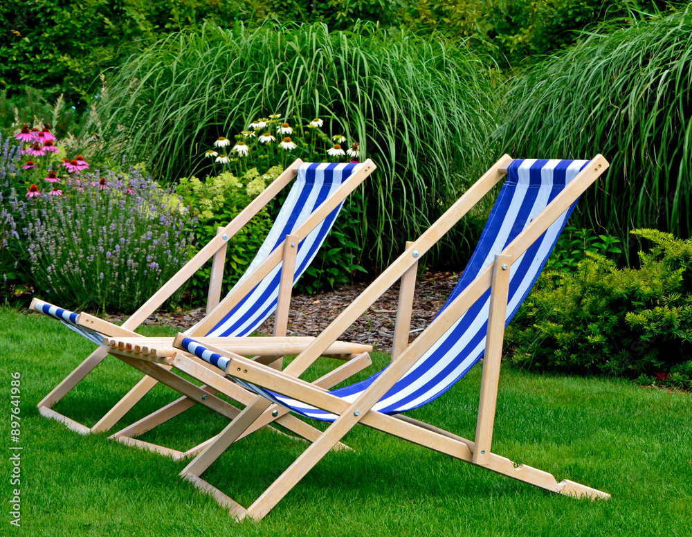 leżaki w biało-niebieskie pasy w ogrodzie, leżaki w ogrodzie, kącik wypoczynkowy z leżakiami, blue and white striped deckchairs in the garden, deckchairs in the garden, empty deck chairs, seating area