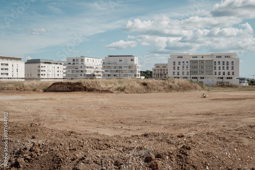 un terrain vide devant devant des nouveaux immeubles neufs , dans un quartier naissant
