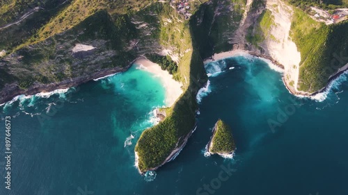 Stunning aerial shot of Kelingking Beach in Nusa Penida, Bali, featuring its iconic cliff formation and pristine turquoise waters. A popular tourist destination known for its dramatic landscape.