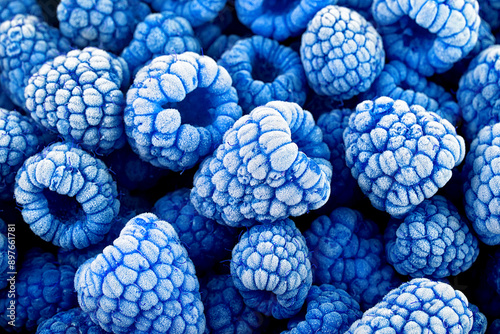 Berries background - frozen blue raspberries covered with hoarfrost. Summer berries, top view. Rubus Leucodermis.