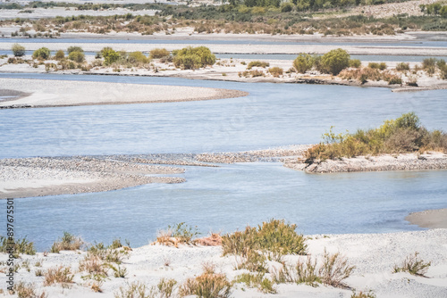 Pyanj River flows in Wakhan Valley among rocky high mountains against snow-capped peaks and glaciers in Tajikistan's Tien Shan mountains, landscape for background photo