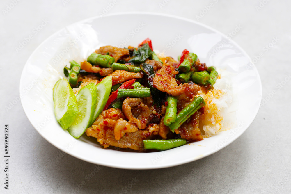Rice topped with stir fried pork and red curry paste with yard-long bean Rice topped with stir fried pork and red curry paste with yard-long bean