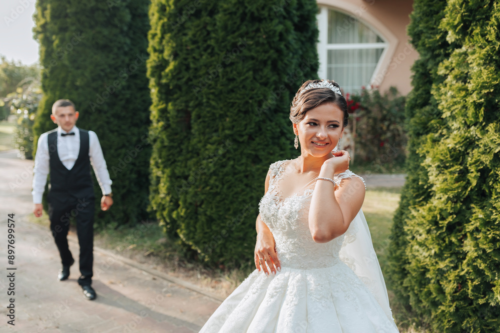 A woman in a white wedding dress stands in front of a wooden door. She is smiling and she is happy A woman in a white wedding dress stands in front of a wooden door. She is smiling and she is happy