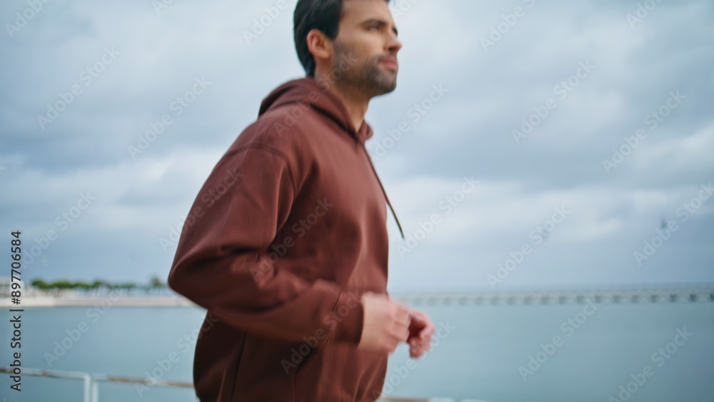 Sportsman running cloudy day at waterfront closeup. Healthy guy enjoying sprint Sportsman running cloudy day at waterfront closeup. Healthy guy enjoying sprint