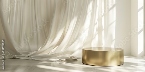 Modern and luxury gold colored round shiny pedestal podium steel in dappled sunlight from window with blowing white sheer curtain in white cream wall background for product display