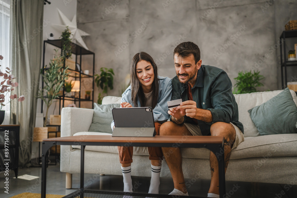 Adult caucasian couple buy online on digital tablet with credit card Adult caucasian couple buy online on digital tablet with credit card