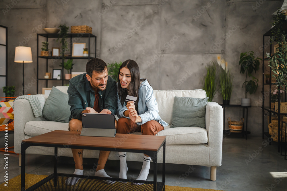 Adult caucasian couple buy online on digital tablet with credit card Adult caucasian couple buy online on digital tablet with credit card