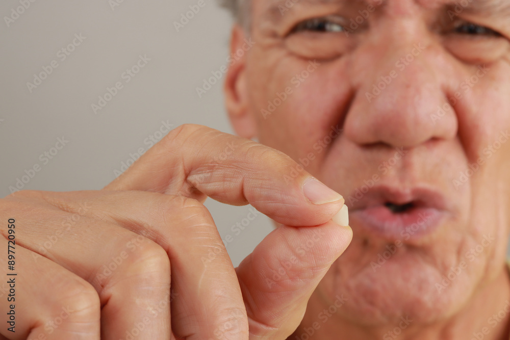 Man holding up and demonstrating his chipped tooth between his fingers. Man holding up and demonstrating his chipped tooth between his fingers.