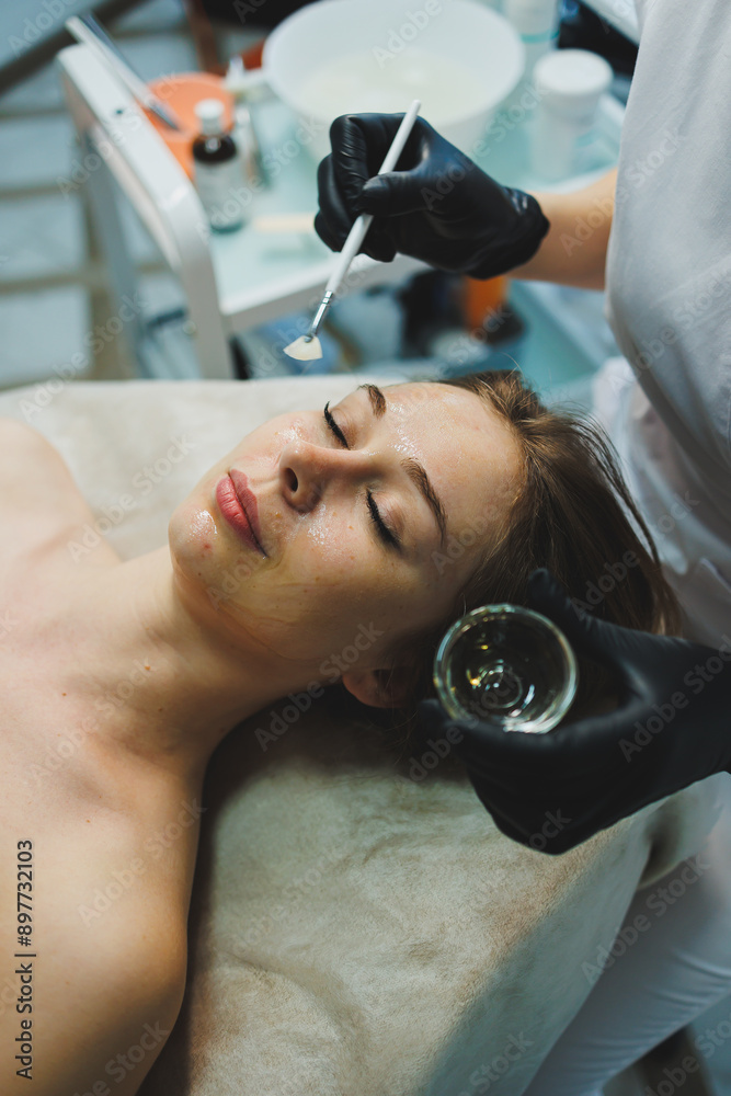 Fototapeta premium A woman with a mask on her face. Facial skin care. A woman's face with an organic mask to moisturize the skin.