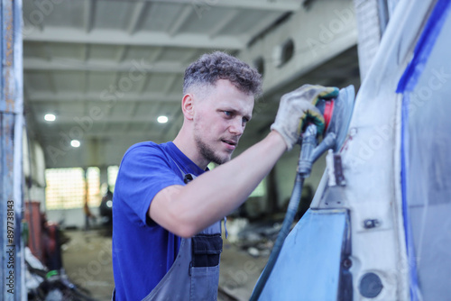 Obraz na płótnie young male master repairs the body of a car van, auto body repair. w salonie