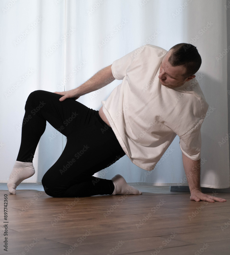 A young athlete performs stretching of his toes. Home workout, muscle stretching A young athlete performs stretching of his toes. Home workout, muscle stretching
