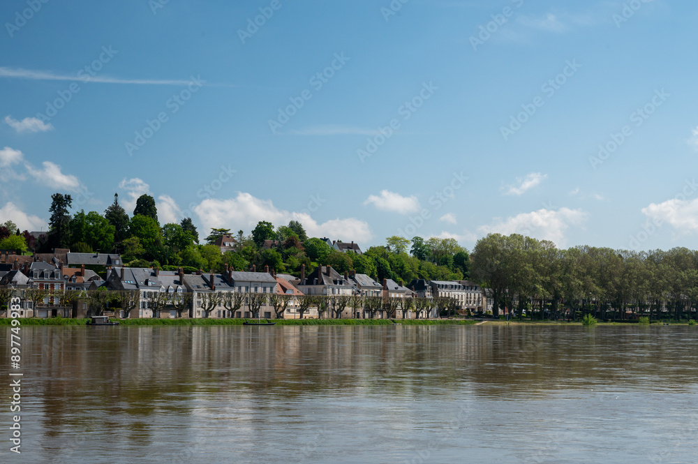 View.on old part of town of Gien on the Loire river, in Loiret department, France, houses with tiled roofs and chimneys, castle and bridge View.on old part of town of Gien on the Loire river, in Loiret department, France, houses with tiled roofs and chimneys, castle and bridge