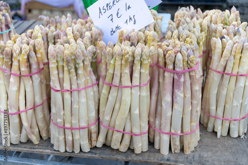 Fresh raw white asparagus vegetables for sale in local farmers market in Souillac, Dordogne, France. English translation: 1 kg bunches asparagus and price photo