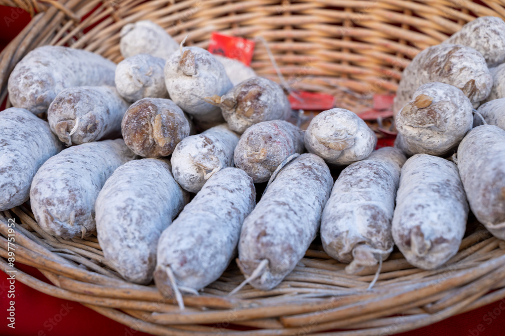 Obraz premium Variety of homemade dried salami sausages in French butchery shop, Dordogne, France, meat food background close up