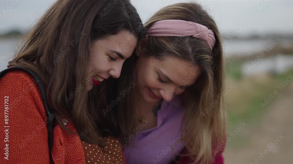 Two women looking at some photos and smiling Two women looking at some photos and smiling