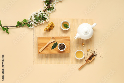 Wallpaper Mural Wooden stand with teapot, cups, dry tea and flowers on beige background Torontodigital.ca