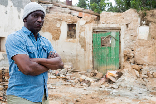 Adult African-american man standing in ruins.