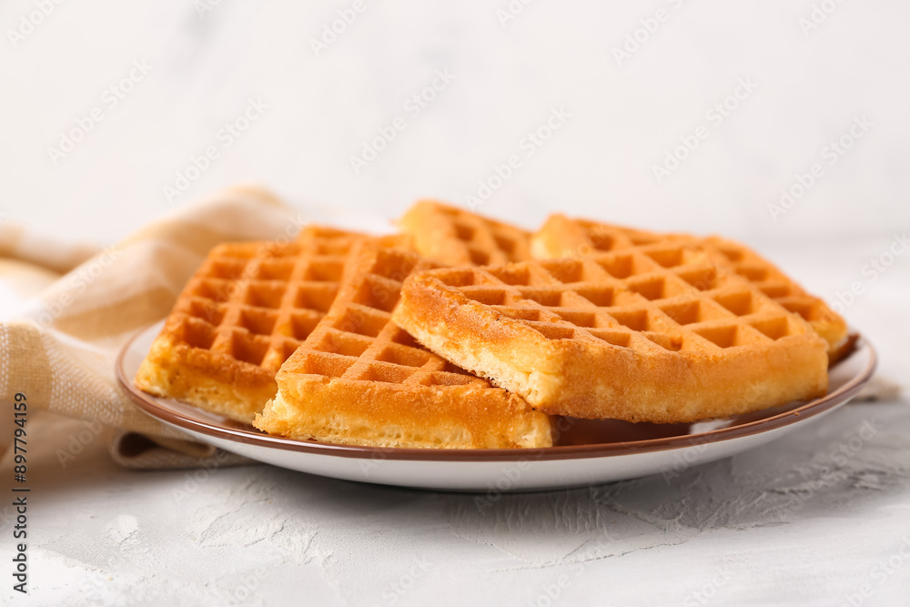 Plate with tasty Belgian waffles on grey table Plate with tasty Belgian waffles on grey table