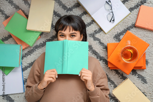 Young woman reading book on...