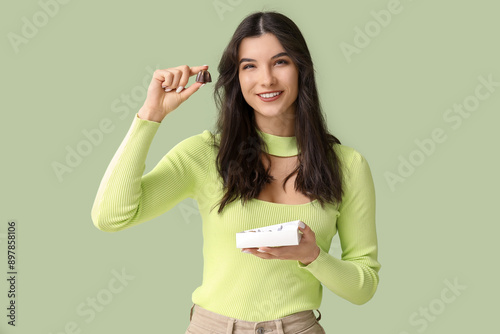 Smiling young woman holding...