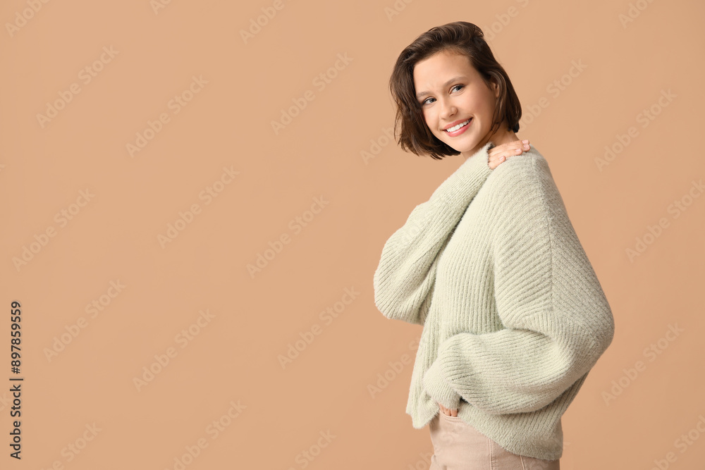 Beautiful young woman in stylish grey sweater on brown background Beautiful young woman in stylish grey sweater on brown background