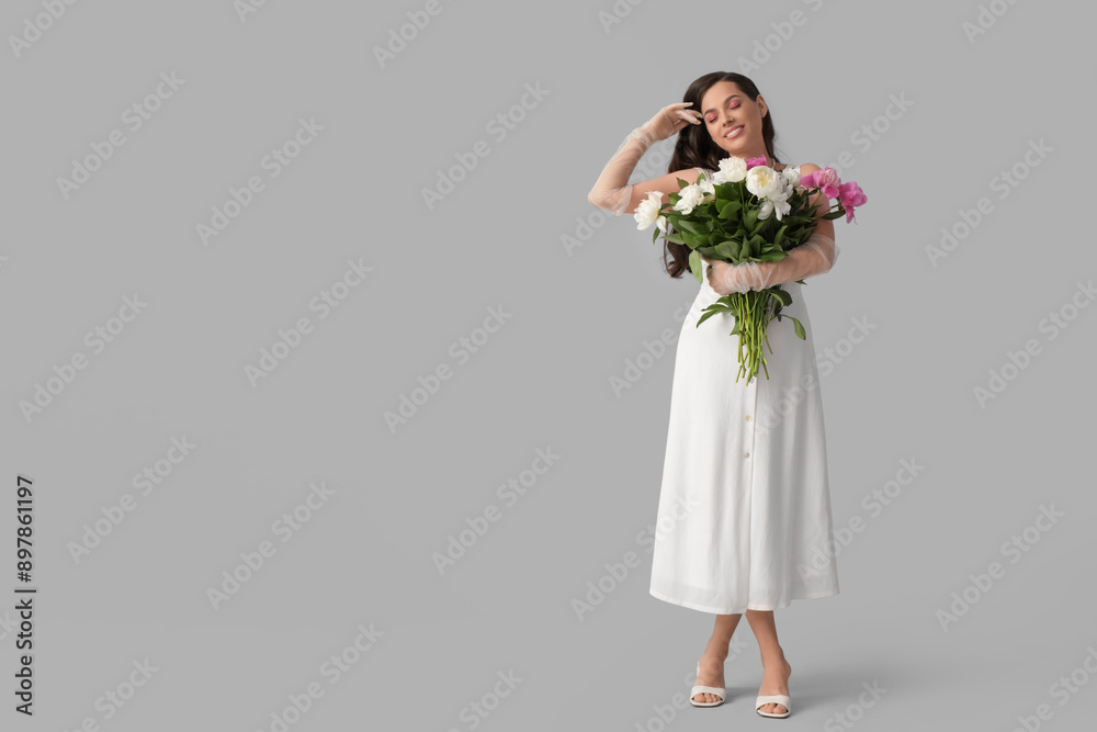 Beautiful young woman with bouquet of peony flowers on grey background Beautiful young woman with bouquet of peony flowers on grey background