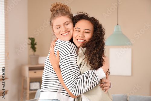 Young women hugging in livi...