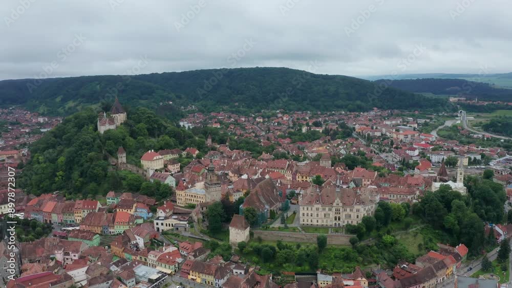 Charming aerial view of a European village with colorful rooftops surrounded by lush green hills Charming aerial view of a European village with colorful rooftops surrounded by lush green hills