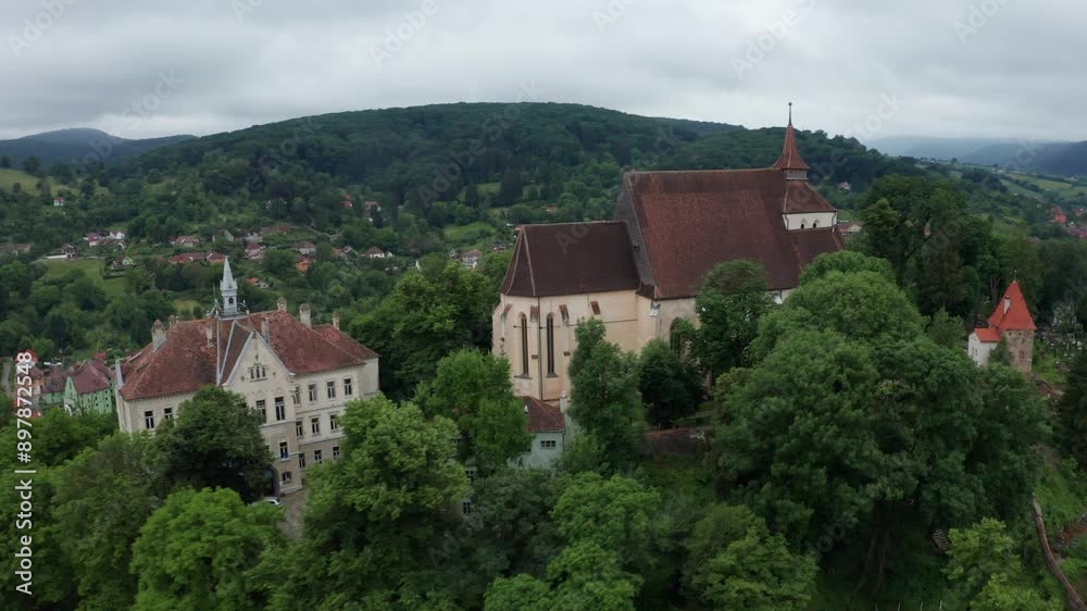 A castle surrounded by lush greenery and rolling hills under a cloudy sky, aerial view A castle surrounded by lush greenery and rolling hills under a cloudy sky, aerial view