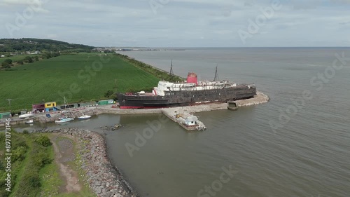 An aerial view of the of the Duke of Lancaster ship at Llannerch-y-Mor Wharf in North Wales on a cloudy day. Flying left to right around the ship photo