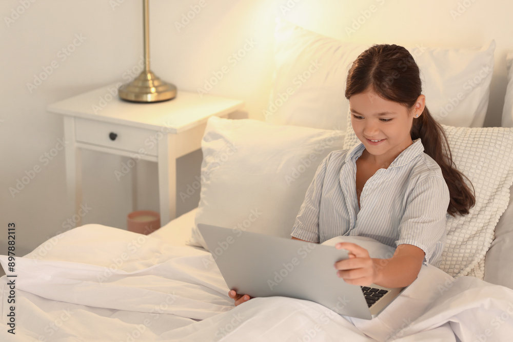 Little girl watching cartoons on laptop in bedroom Little girl watching cartoons on laptop in bedroom