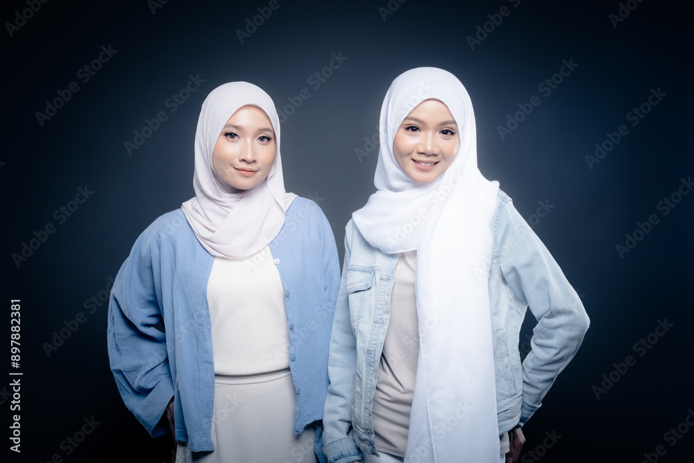 Portrait of a beautiful Malaysian and Indonesian Muslim young women wearing modern and casual wear with hijab on isolated studio background. Modern hijab fashion and beauty concept Portrait of a beautiful Malaysian and Indonesian Muslim young women wearing modern and casual wear with hijab on isolated studio background. Modern hijab fashion and beauty concept